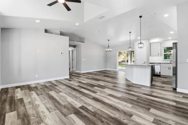 a view of kitchen and kitchen with stainless steel appliances wooden floor
