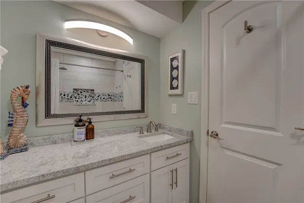 a bathroom with a sink a mirror and shower