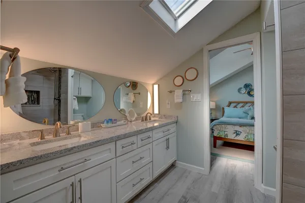 a en suite bathroom with a granite countertop sink and a mirror