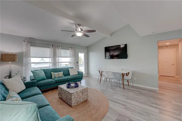 a living room with furniture a flat screen tv and a window