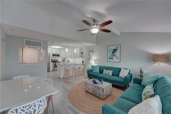 a living room with furniture and a view of kitchen