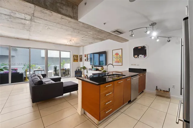 a kitchen with stainless steel appliances granite countertop a stove and a view of living room