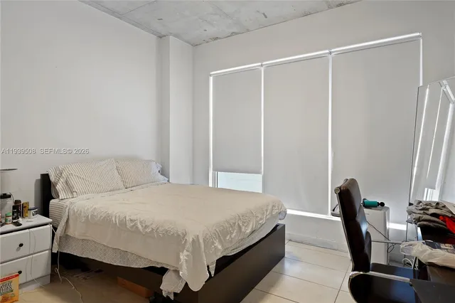 a bedroom with a bed and a chair in it