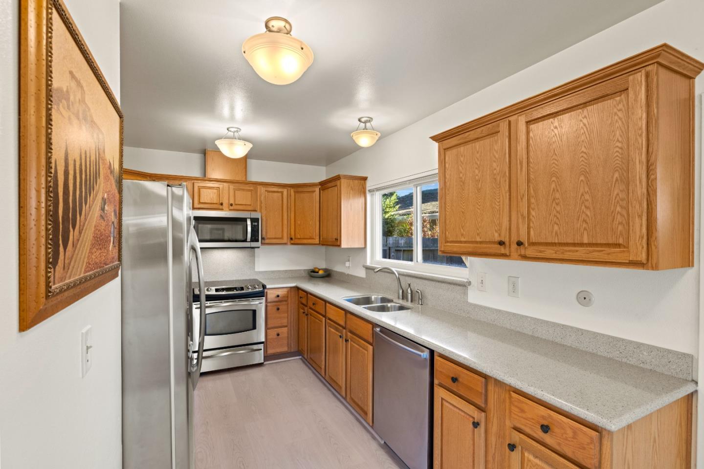 902 Maple Street Pacific Grove, CA 93950 - Photo 13 of 35 a kitchen with stainless steel appliances a sink cabinets and wooden floor