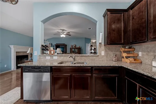 a kitchen with granite countertop a sink stainless steel appliances and cabinets