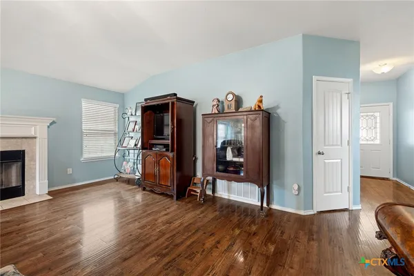 a view of a livingroom with wooden floor and furniture