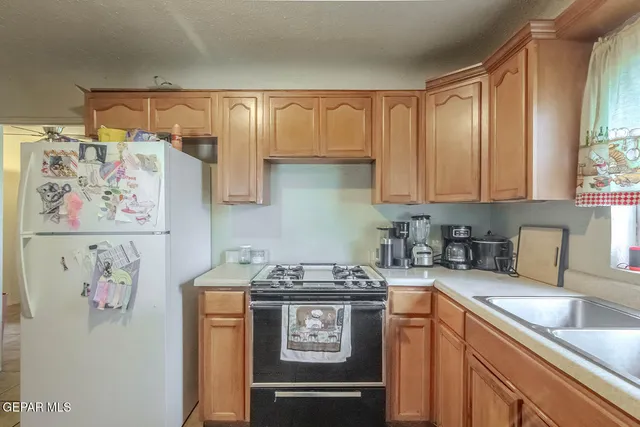 a kitchen with stainless steel appliances granite countertop a sink stove and cabinets