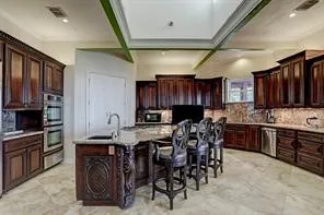 a kitchen with stainless steel appliances granite countertop table chairs sink and cabinets