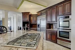 a kitchen with kitchen island granite countertop a stove and a sink