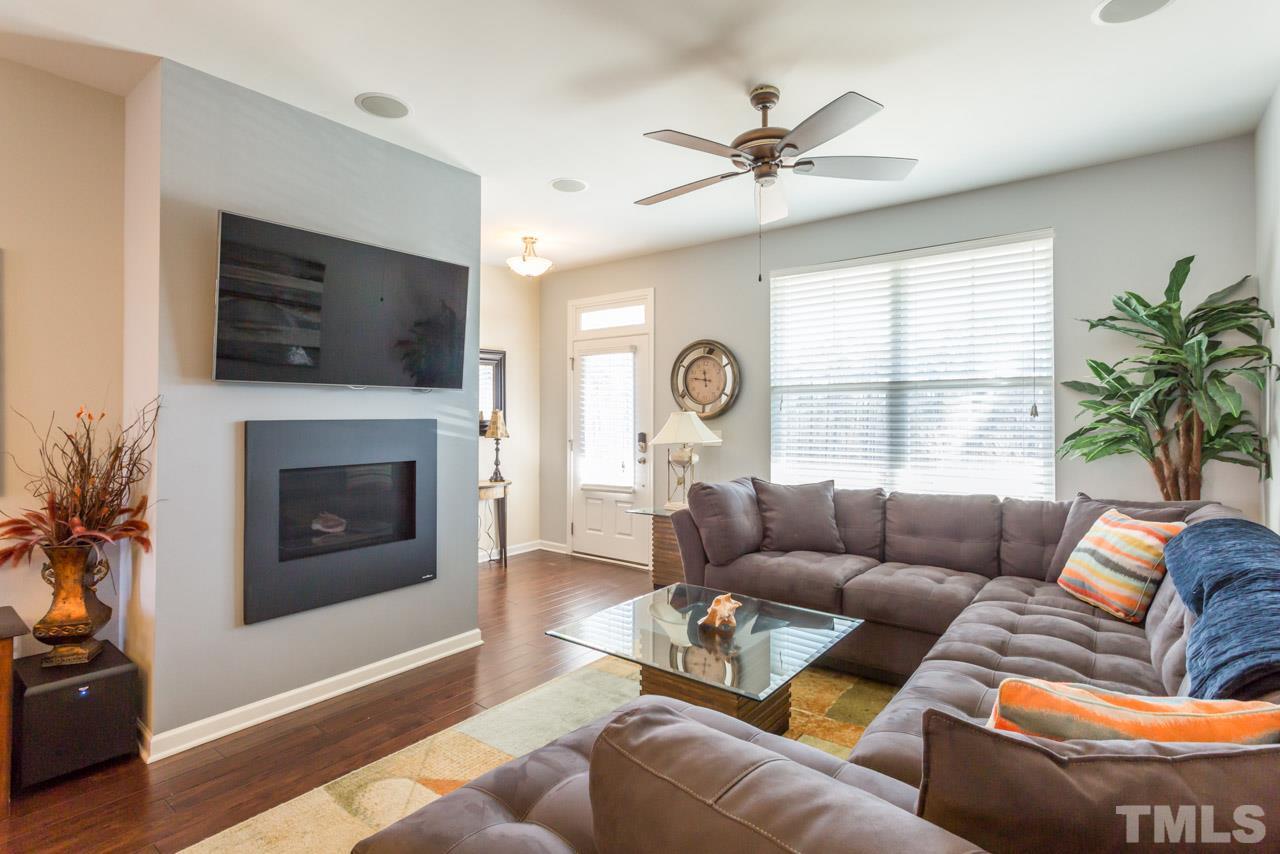 1655 Crafton Way Raleigh, NC 27607 - Photo 6 of 25 a living room with furniture a large window and a fireplace