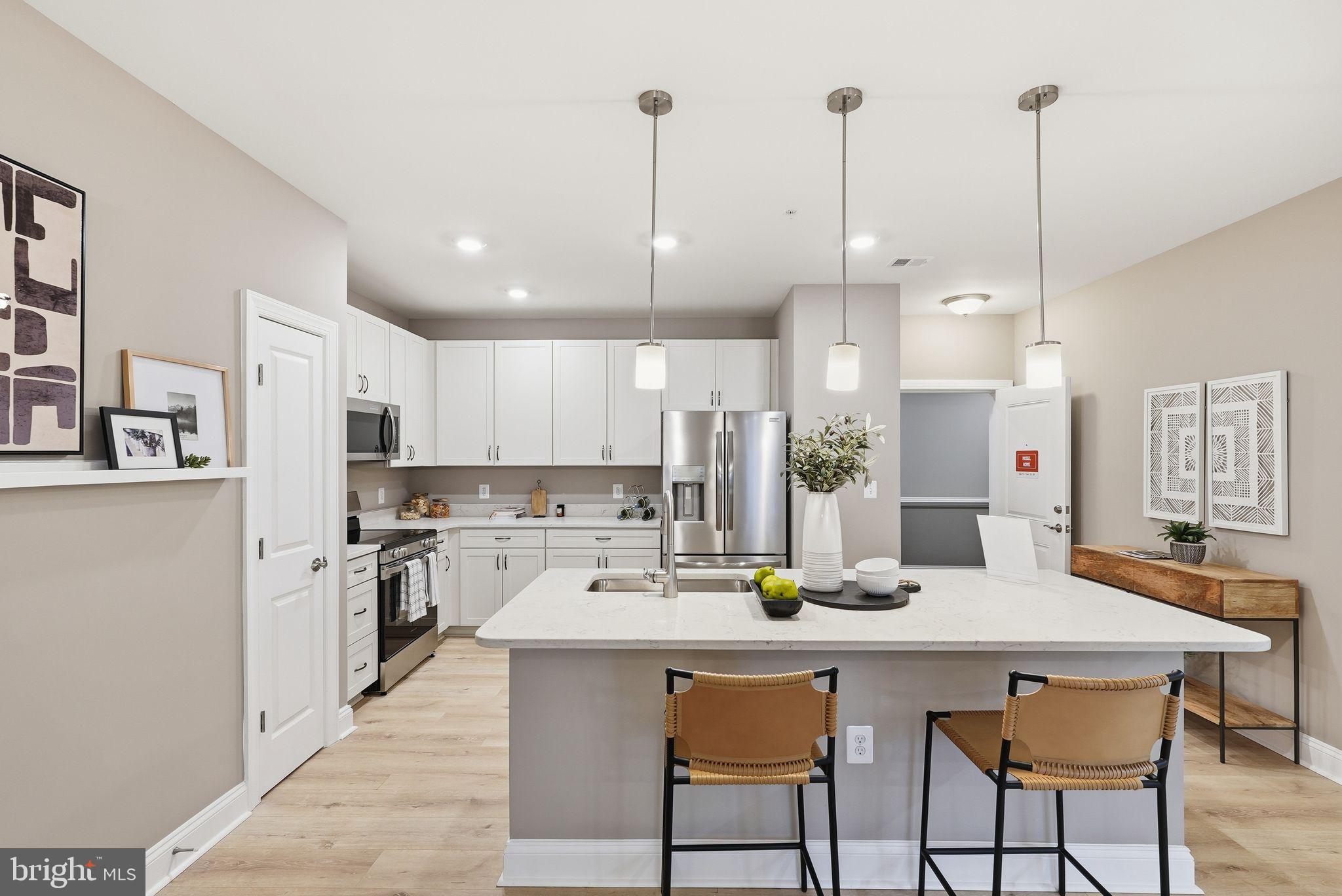 a kitchen with stainless steel appliances kitchen island granite countertop a dining table chairs and white cabinets