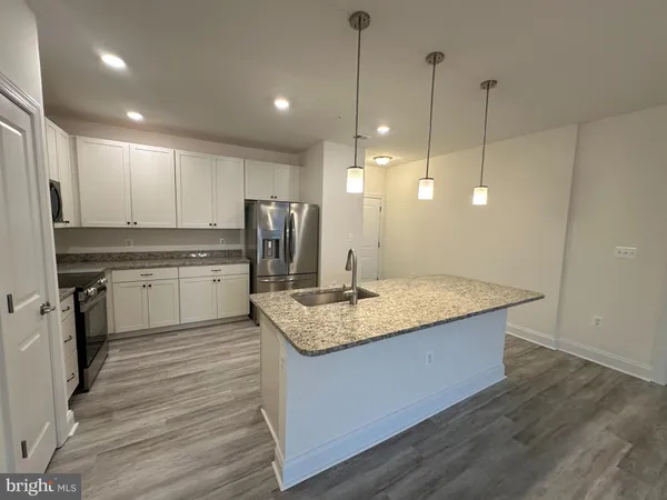 a kitchen with granite countertop a refrigerator and a sink