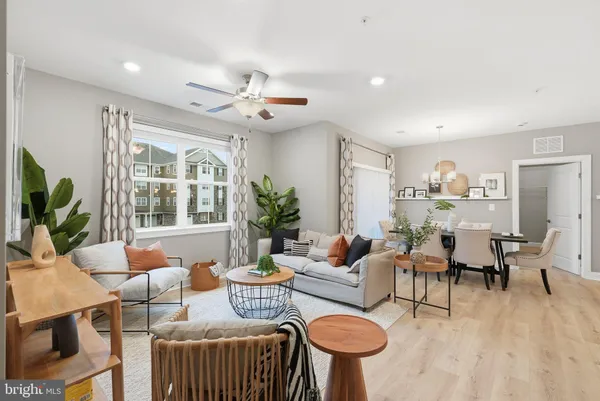 a living room with furniture kitchen view and a large window