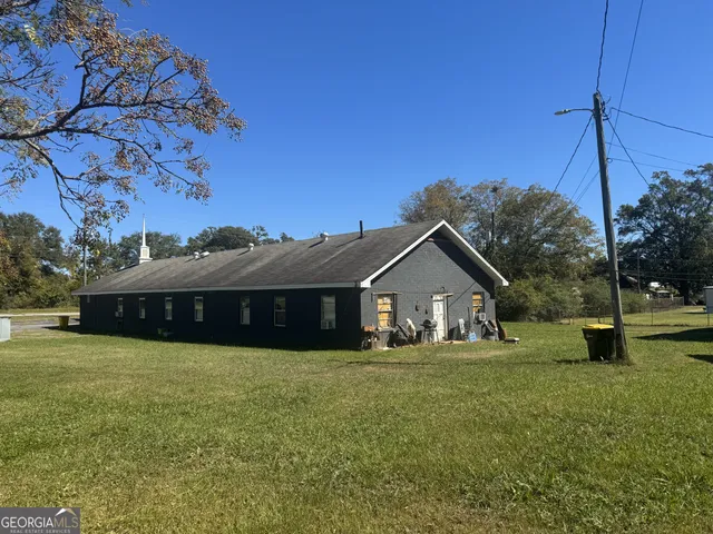 a white house with a big yard and large trees
