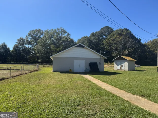 a view of a house with a yard and large tree