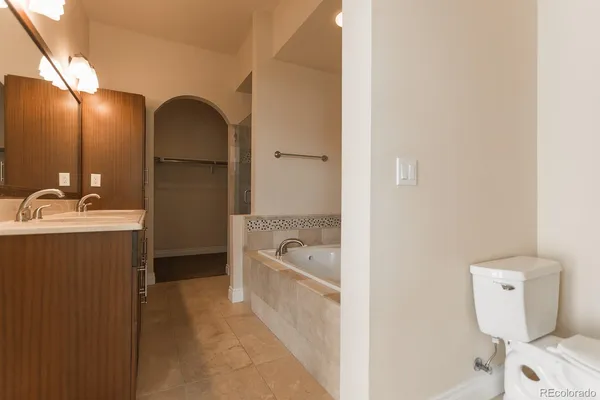 a bathroom with a tub sink toilet and a mirror