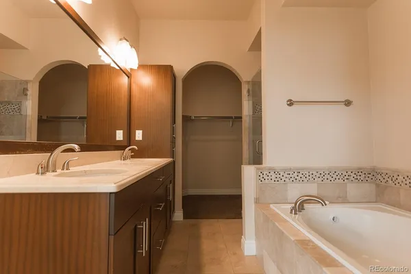 a bathroom with a tub sink and mirror