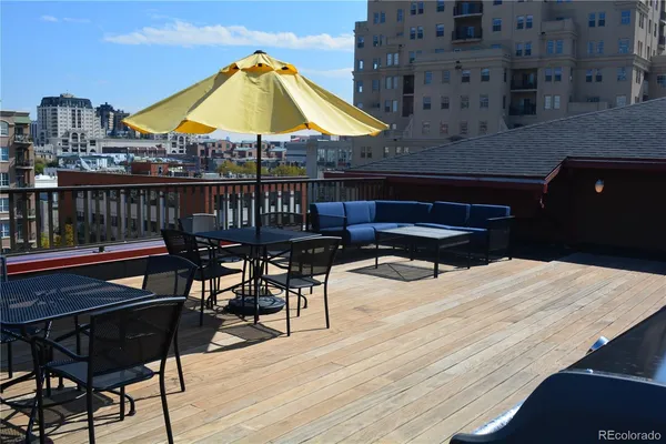 a patio with a table and chairs under an umbrella