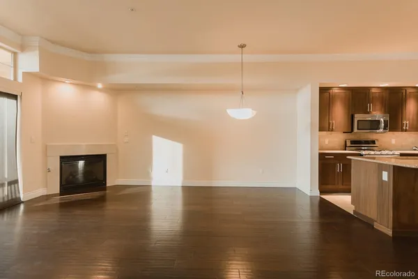 a view of empty room with wooden floor and fireplace