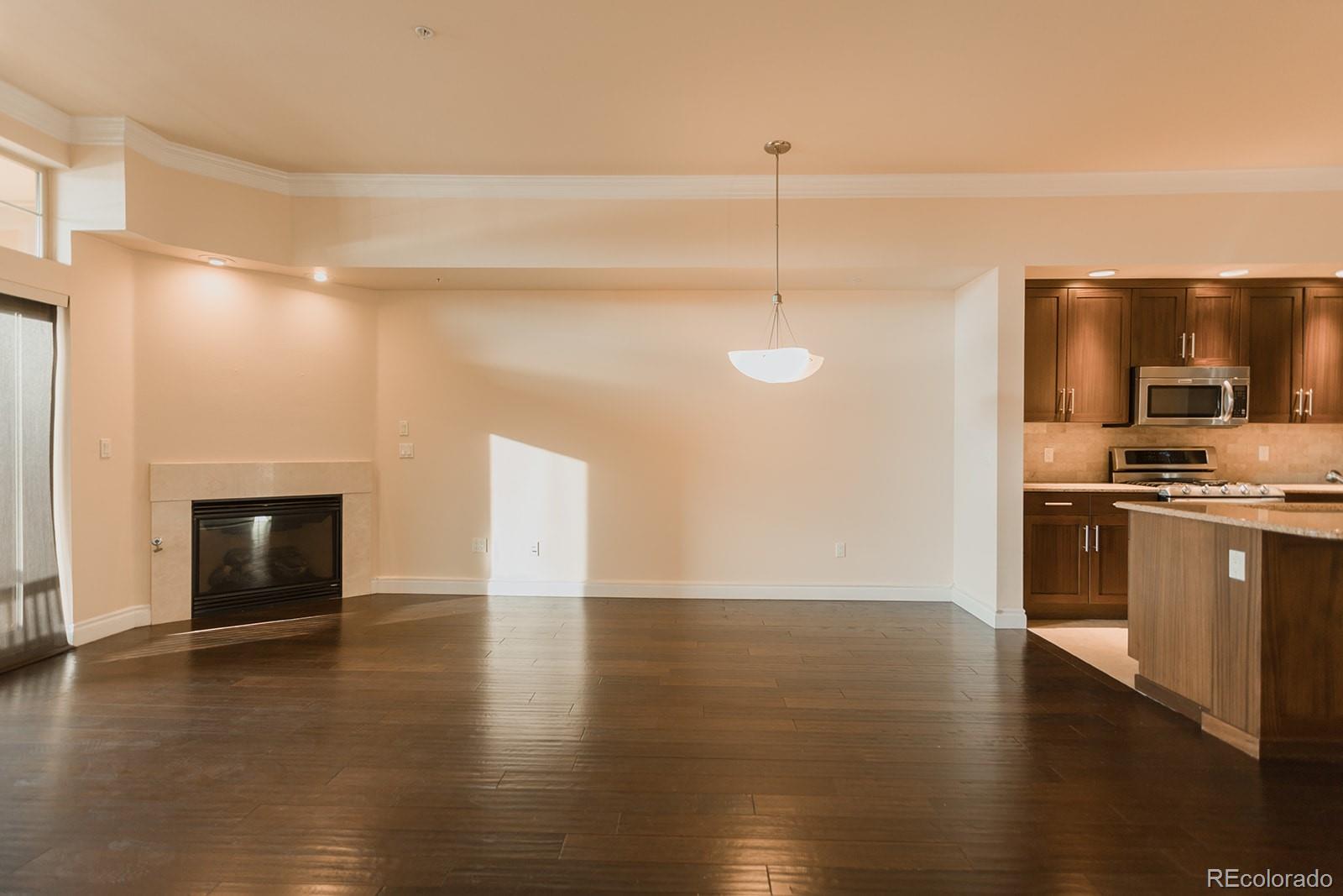 1120 Delaware Street, Unit 201 Denver, CO 80204 - Photo 3 of 25 a view of empty room with wooden floor and fireplace