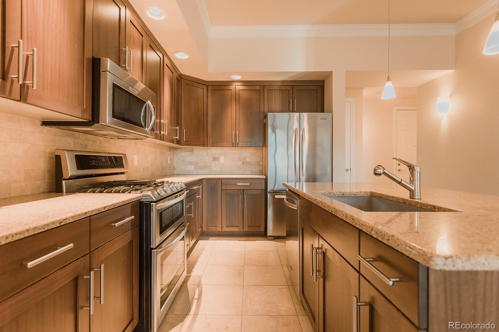 1120 Delaware Street, Unit 201 Denver, CO 80204 - Photo 5 of 25 a kitchen with stainless steel appliances granite countertop a sink stove and refrigerator