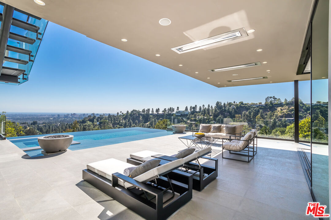 9406 Lloydcrest Drive Beverly Hills, CA 90210 - Photo 6 of 52 a view of a terrace with furniture and outdoor kitchen