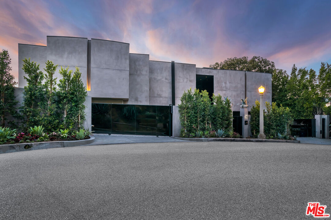 9406 Lloydcrest Drive Beverly Hills, CA 90210 - Photo 9 of 52 a front view of a house with a yard and garage
