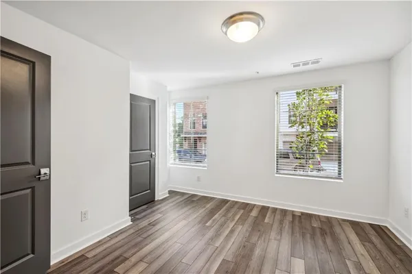 an empty room with wooden floor and windows