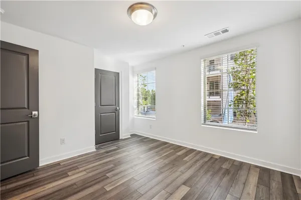 an empty room with wooden floor and windows