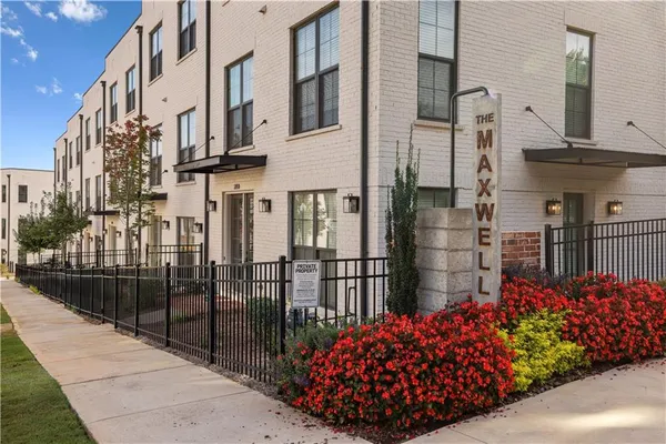 a view of a wooden house with a flower garden