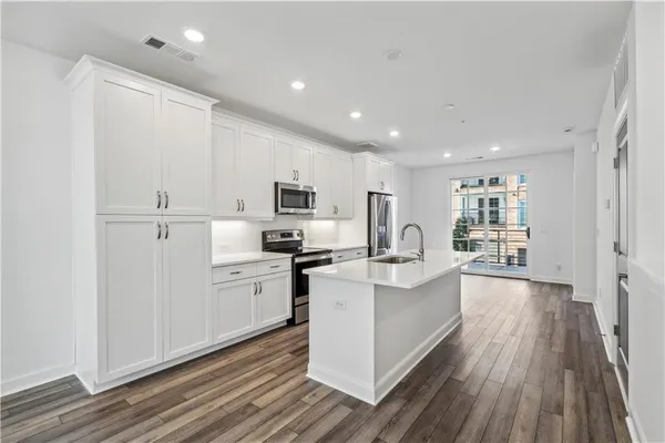 a kitchen with white cabinets and white appliances