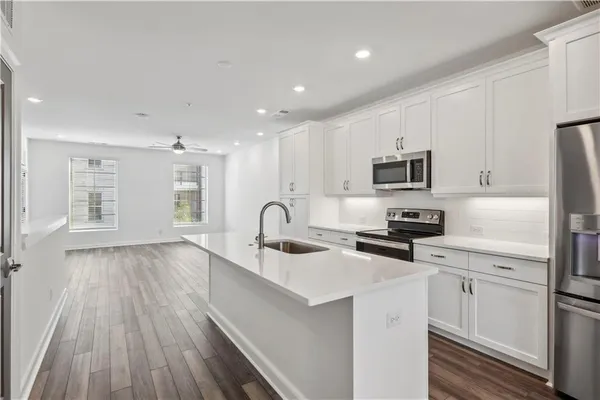 a kitchen with sink a microwave and cabinets