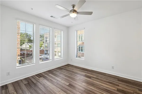 a view of an empty room with a window and wooden floor