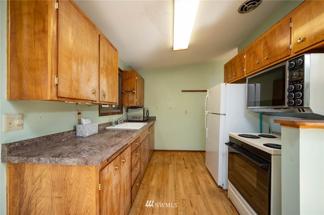 18101 Beall Road Southwest Vashon, WA 98070 - Photo 14 of 37 a kitchen with granite countertop a sink a counter top space stainless steel appliances and cabinets
