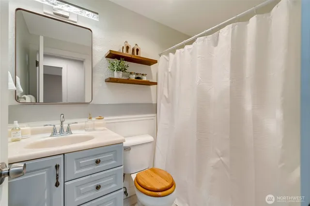a bathroom with a sink a toilet and a mirror