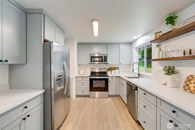 a kitchen with stainless steel appliances a refrigerator sink and microwave