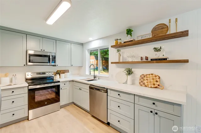 a kitchen with white cabinets and appliances