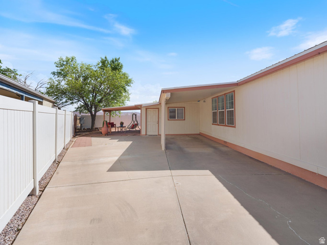 3941 West 40 North Hurricane, UT 84737 - Photo 4 of 55 Expansive concrete driveway with an attached carport, featuring multiple windows on the exterior wall