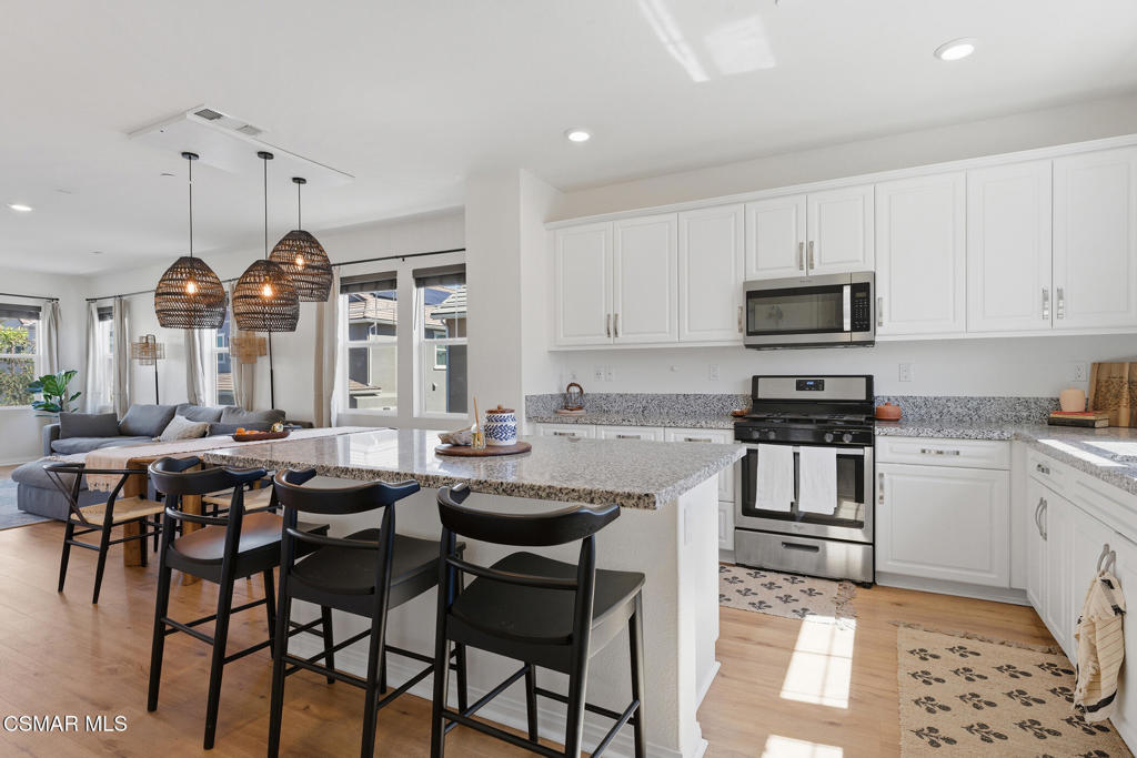 512 Mulberry Lane Fillmore, CA 93015 - Photo 13 of 54 a kitchen with granite countertop a stove a sink a dining table and chairs