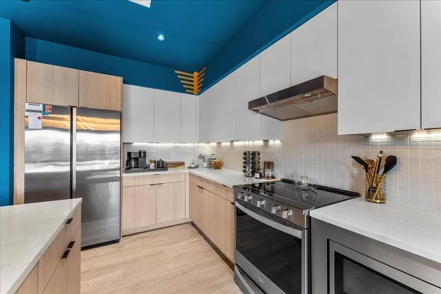 a kitchen with stainless steel appliances a sink a stove and cabinets