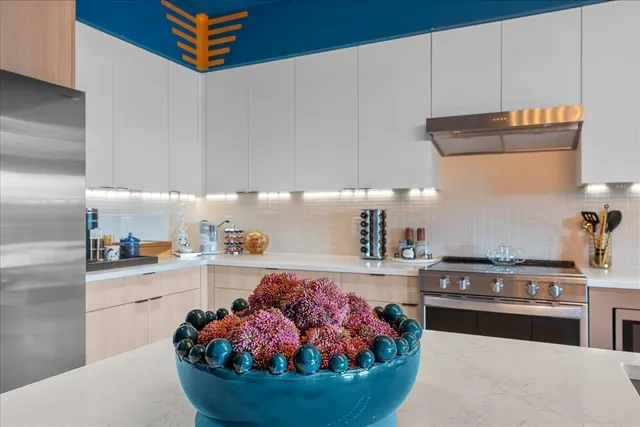 a kitchen with stainless steel appliances granite countertop a sink a stove and a refrigerator