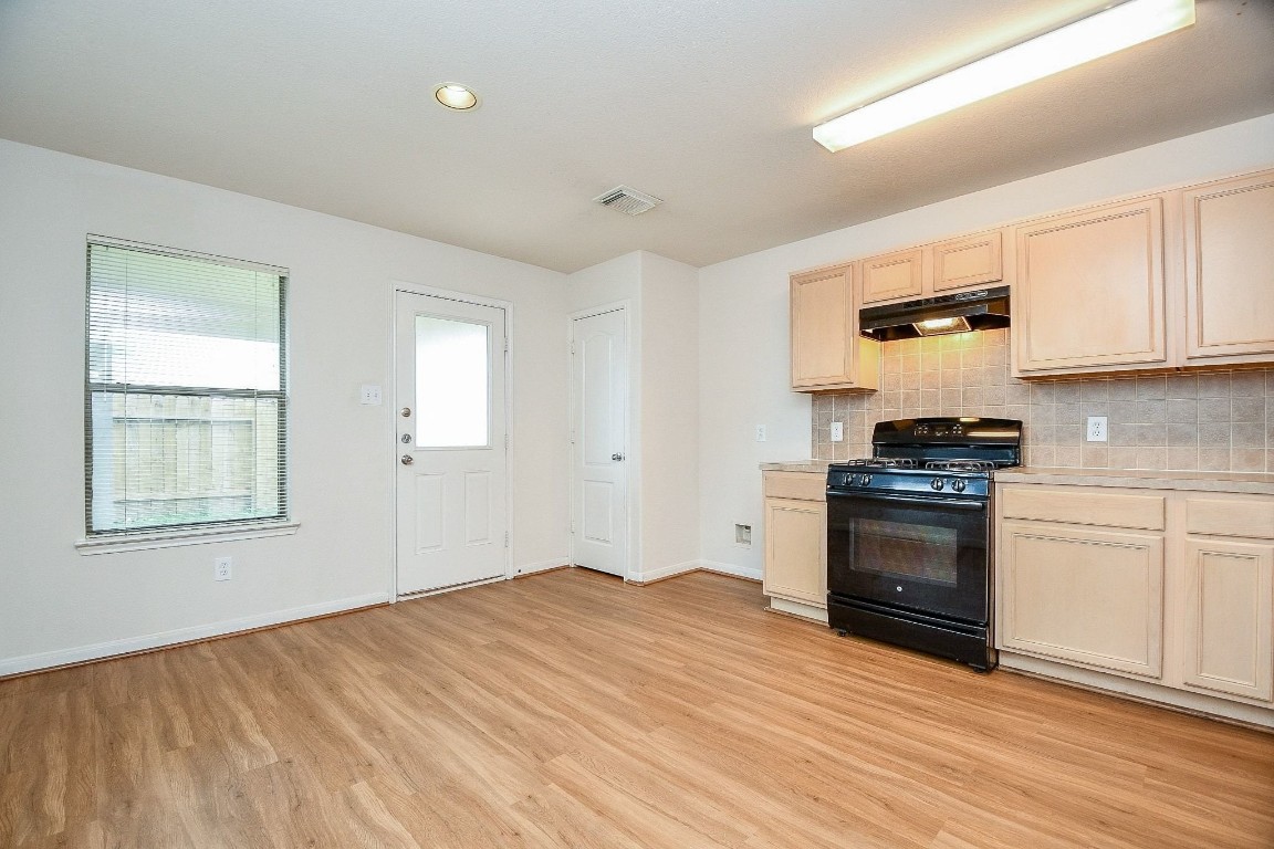 29530 Legends Glen Drive Spring, TX 77386 - Photo 11 of 50 a kitchen with granite countertop a stove and a wooden floors