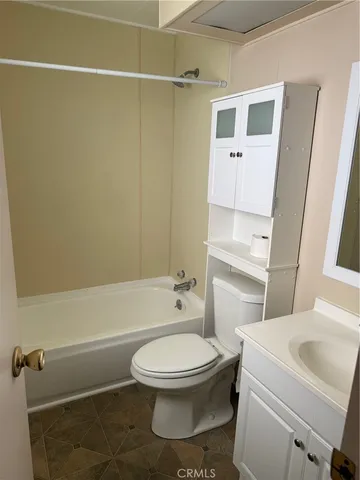 a white toilet sitting next to a bathroom sink and a shower