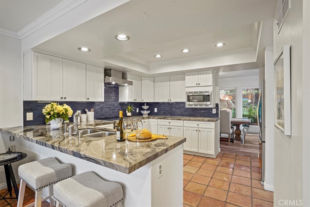 23802 Cassandra Bay Dana Point, CA 92629 - Photo 9 of 56 a kitchen with kitchen island granite countertop a sink cabinets and counter space