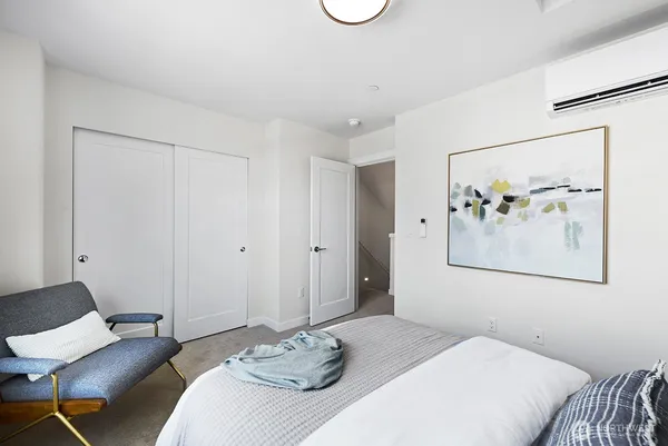 a bedroom with a bed and painting on the wall