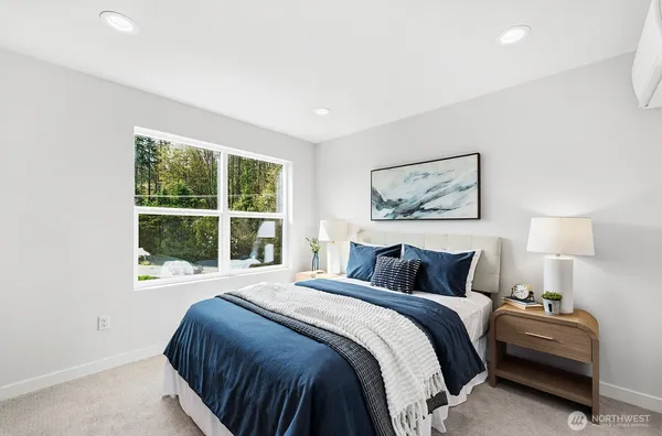 a bedroom with a bed and a large window