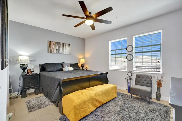 a bedroom with a bed a couch and a potted plant