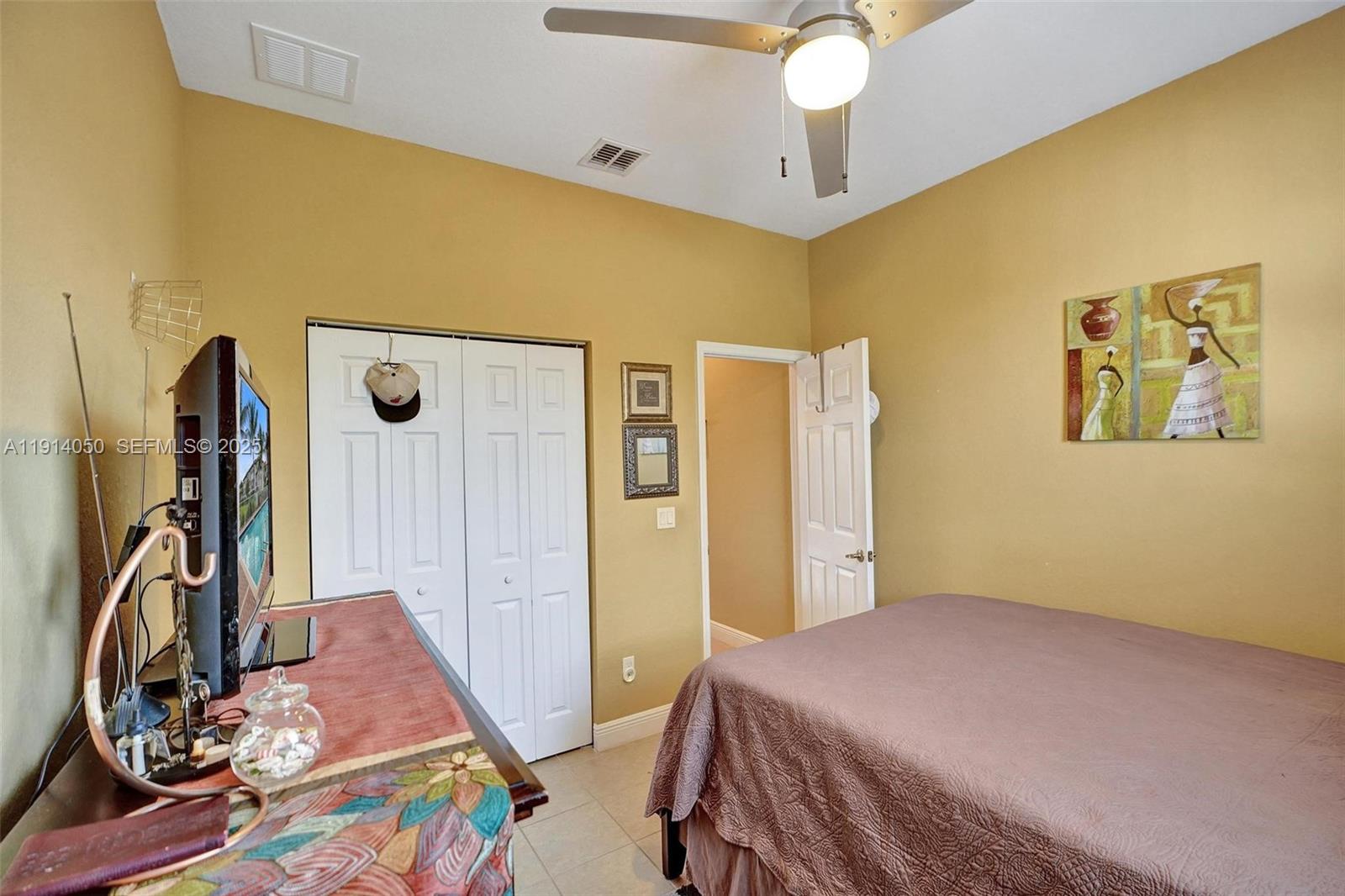 2659 Southwest 118 Road Miramar, FL 33025 - Photo 19 of 28 a bedroom with a bed and a chandelier