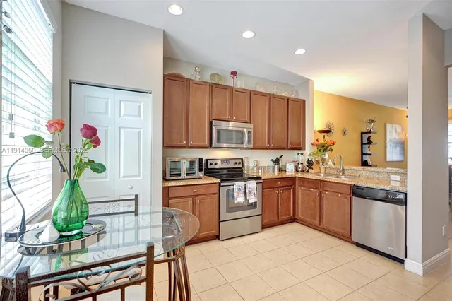 a kitchen with stainless steel appliances granite countertop sink stove top oven and microwave