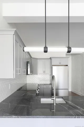 a kitchen with kitchen island granite countertop a counter top space cabinets and stainless steel appliances